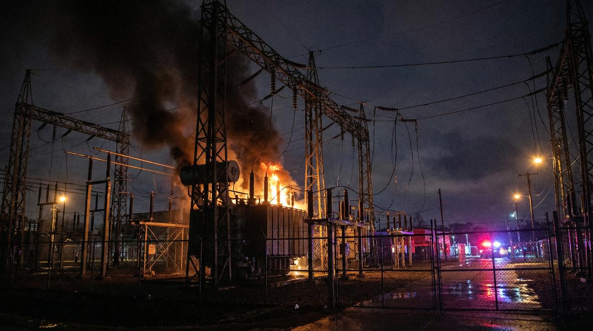 Electrical substation on fire at night, showing grid vulnerability